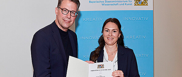 Die Würzburger Professorin Daniela Lorenz erhält von Bayerns Wissenschaftsminister Markus Blume ihren Preis für gute Lehre.