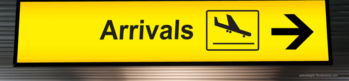 Gelbes Schild am Flughafen "Arrivals".