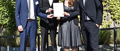 Oliver Hunke from the BMWi hands the certificate to the founding team of integrAi.de: Thomas Glaser, Bianca Heim and Joscha Riemann (from left to right). (Picture: project sponsor Jülich/ T. Großmann)