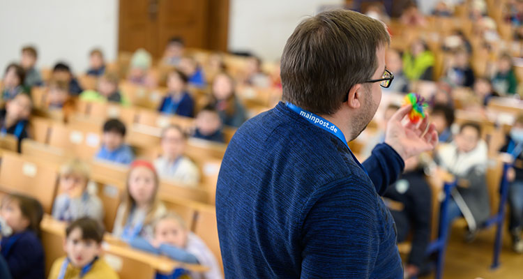 Ein Professor hält im Rahmen der Kinderuni der JMU einen Vortrag vor Kindern.