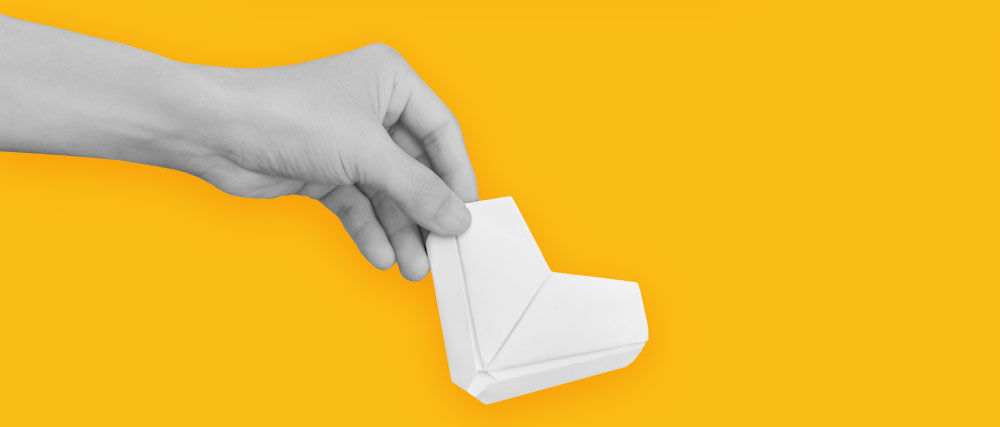 eine Hand, die ein Papierherz auf gelbem Hintergrund hält