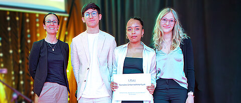 Tanja Golly (l.) von der Uni Würzburg überreichte den ersten Preis in der Kategorie „Soziales Unternehmertum“ an eine Delegation des Wahlfachs „Schülerfirma“ der Wallburg-Realschule Eltmann.