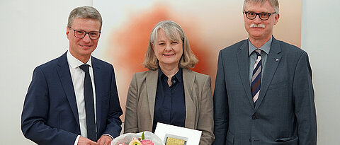 Minister Bernd Sibler (l.) überreichte Professorin Andrea Szczesny die Auszeichnung. Beim Festakt in München war JMU-Kanzler Uwe Klug (r.) dabei.