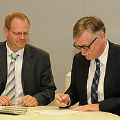 Unikanzler Uwe Klug (rechts) und Dieter Körber, Geschäftsleitung des Team INklusiv, unterzeichnen die Absichtserklärung zur Patenschaftsvereinbarung. (Foto: Karsten Fehr)