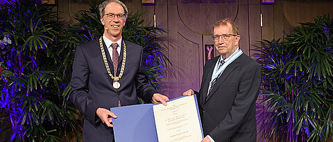 Alfred Forchel (rechts) wurde auf dem Stiftungsfest 2022 mit der Ehrensenatorwürde ausgezeichnet. Ihm gratulierte Universitätspräsident Paul Pauli.