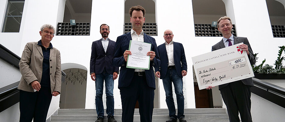 Dr. Markus Elsholz (Mitte) wurde von Univizepräsidentin Ulrike Holzgrabe (links) und Holger Schumacher (Ergon-Verlang, rechts) der Bildungsforschungspreis 2020 verliehen.