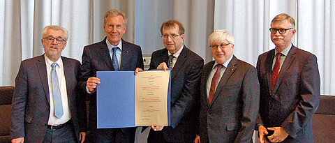 Urkundenübergabe im Senatssaal (von links): Stiftungsgeschäftsführer Herbert Meier, Altbundespräsident Christian Wulff, Universitätspräsident Alfred Forchel, Professor Friedhelm Brusniak und Unikanzler Uwe Klug. (Foto: Marco Bosch)