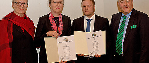 Preisverleihung in München: Wissenschaftsminister Ludwig Spaenle (rechts) und Vizepräsidentin Barbara Sponholz (Universität Würzburg, links) gratulieren den Preisträgern Anke Krüger und Philipp Singer (Foto: Friedrich Schmidt, LMU)