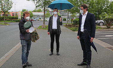 Ortstermin im Würzburger Stadtteil Heuchelhof: Dr. Marcell Peters (links) zeigt Gartenamtsleiter Dr. Helge Bert Grob (Mitte) und Klimabürgermeister Martin Heilig eine Fensterfalle. Damit werden fliegende Insekten wie Wildbienen, Hummeln oder Wanzen gefangen.