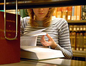 Studentin zwischen Bücherregalen der Würzburger Universitätsbibliothek. (Foto: Gunnar Bartsch)