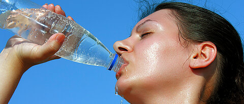 Frau, die aus einer Flasche Wasser trinkt