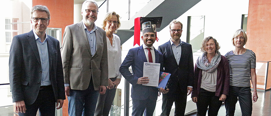 Dr. Hardikkumar Jetani (Mitte) mit dem Promotionskomitee und Vertreterinnen der Graduate School (v.l.): Prüfungsvorsitzender Professor Thomas Rudel, Professor Thomas Herrmann, PD Dr. Friederike Berberich-Siebelt, Dr. Michael Hudecek, Dr. Gabriele Blum-Oehler, Professorin Caroline Kisker.