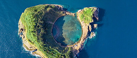 An island of the Azores: It is an example of an underwater volcano that has reached the sea surface. The crater is clearly visible.