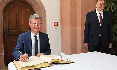 Im Anschluss an das Stiftungsfest hat sich Minister Bernd Sibler ins Goldene Buch der JMU eingetragen.