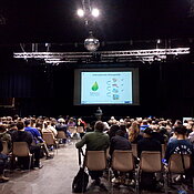 Rund 300 Schülerinnen nehmen an der Schulmesse teil. Sie sitzen in einem Vortrag zum Klimawandel.