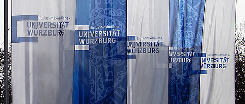 Weiße und blaue Fahnen mit dem Logo der Universität Würzburg drauf