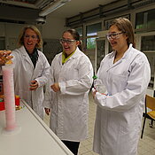 Carina Krell und Sarah Skrzypczyk bereiten mit Katja Weirauch den Versuch „Wer macht den meisten Schaum?“ vor (von rechts). (Foto: Annette Popp)