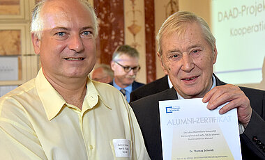 Thomas Schmidt (links) ging vor 25 Jahren nach einer Promotion in Chemie von der Uni ab. Theodor Berchem, Vorsitzender des Alumni-Vereins, überreichte ihm ein Zertifikat.