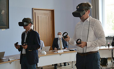 Mit einer Virtual Reality-Brille betrat WissenschaftsministerSibler (links) einen virtuellen Konferenzraum mit direkter Interaktion mit anderen Teilnehmern - und wenig später auch mit KI-gestützten Charakteren.