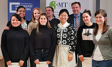 Die sechs Teilnehmerinnen gemeinsam mit Esther Knemeyer, Pressesprecherin der JMU (Dritte v. li.), Stephan Schröder-Köhne und Professor Matthias Bode. (Bild: Theresa König / Uni Würzburg)