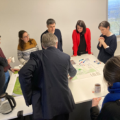 Expertenrunde steht um den Campusplan und ist in eine Diskussion vertieft