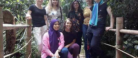 Besuch aus Kairo, Gruppenbild im Gewächshaus. 3 Gastwissenschaftlerinnen, 2 Studierende der Museologie sowie Simone Doll-Gerstendörfer und Dr. Kerstin Bissinger stehen auf einem Steg im Gewächshaus