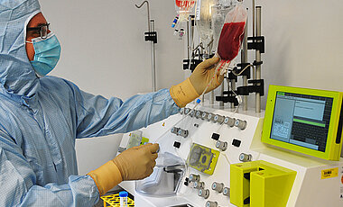 Der Leiter der Qualitätskontrolle, Diplom-Biologe Johannes Rachor, im Reinraumbereich des GMP-Zelltherapie-Labors beim Bestücken eines neuen, vollautomatischen Zellseparators.