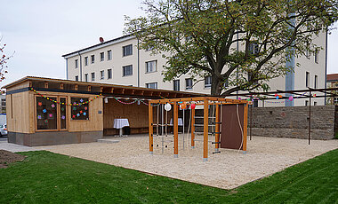 Das Tiny House mit Veranda und Spielfläche.