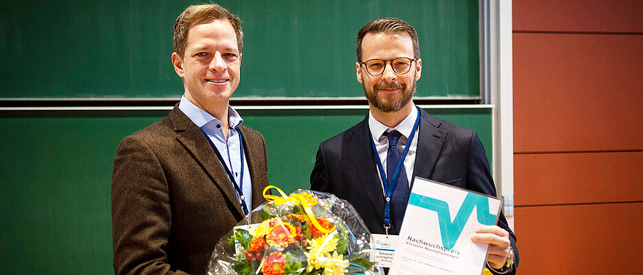 Christian Grefkes-Hermann überreicht den DGKN-Nachwuchsförderpreis für Klinische Neurophysiologie an Sebastian Schreglmann. 