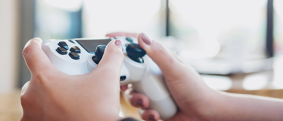 A woman is holding a controller for a game console in her hand. Researchers have wondered whether video games make people fat.Eine Frau hält einen Controller für eine Spielekonsole in der Hand. Forscher haben sich gefragt, ob Videospiele dick machen.