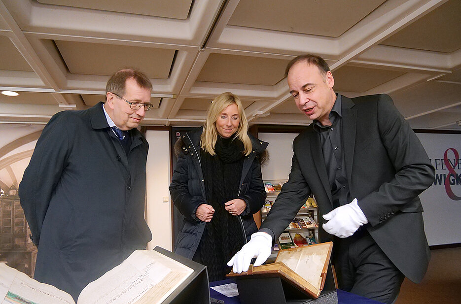 Hans-Günter Schmidt präsentierte Anna Stolz und Alfred Forchel wertvolle historische Stücke aus der Würzburger Universitätsbibliothek.