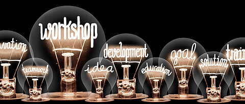 Adobe Stock Images Photo of light bulbs with shining fibers in a shape of Workshop, Training, Goal, Development and Motivation concept related words isolated on black background