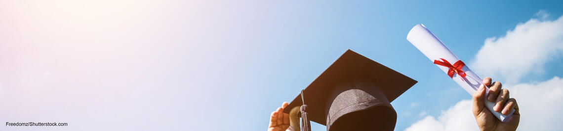 Eine Person streckt einen akademischen Hut und eine Urkunde in die Luft.