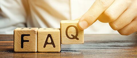 Adobe Stock Images Businessman puts wooden blocks with the word FAQ (frequently asked questions). Collection of frequently asked questions on any topic and answers to them. Instructions and rules on Internet sites