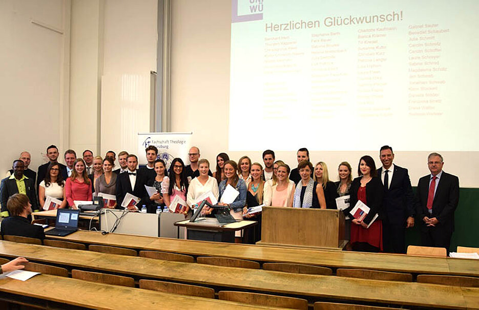 Die Absolventinnen und Absolventen des Sommersemesters 2016 mit Dekan Martin Stuflesser (2.v.r.), Prodekanin Barbara Schmitz (am Rednerpult) und Studiendekan Wolfgang Weiß (r.). (Foto: Michael Müller)