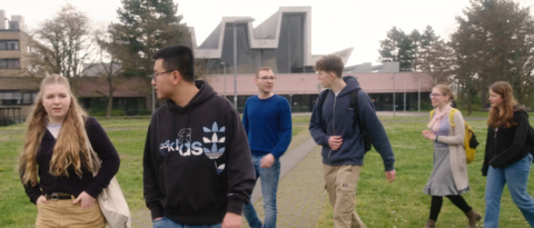Studierende laufen über den Campus