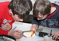 Mit einem Kamm untersuchen zwei Schüler die Brechung von Licht. Foto: Thomas Trefzger