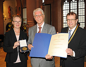 Herbert Wellhöfer bekommt von Universitätspräsident Alfred Forchel (r.) und Vizepräsidentin Barbara Sponholz die Röntgenmedaille überreicht. (Foto: Robert Emmerich)