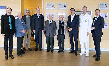 Gruppenbild zur feierlichen Enthüllung mit (v.l.): Marcus Holtz (Uniarchiv), Walter Eykmann (Initiator), Matthias Frosch (Dekan der Medizinischen Fakultät), Unipräsident Paul Pauli, den Initiatoren August Heidland und Horst Brunner, Tim von Oertzen (Ärztlicher Direktor UKW), ???? und Andreas Buck (Nuklearmedizin).