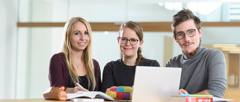 Gruppe mit drei Personen und Notebook