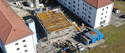 Der Neubau steht zwischen zwei Bestandsgebäuden der ehemaligen Leighton Baracks, die heute vom Mathematischen Institut genutzt werden. 