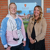 Etienne-Fabrice Hees und Laura Slesiona vor einem Plakat, das am Institut für Geschichte für einen Aufenthalt am Flagler College in den USA wirbt.