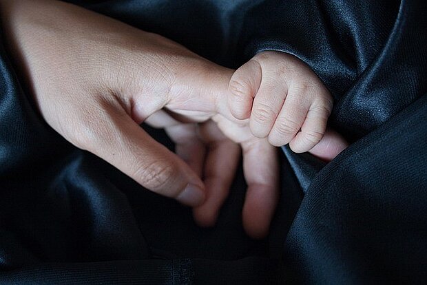 Babyhand greift Finger