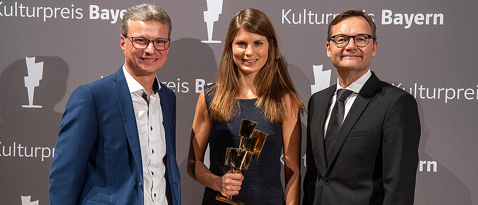 Dr. Frederike Middelhoff bei der Verleihung des Kulturpreises Bayern 2019. Überreicht wurde der Preis von Reimund Gotzel, Vorstandsvorsitzender der Bayernwerk AG (rechts), und Staatsminister Bernd Sibler (links).