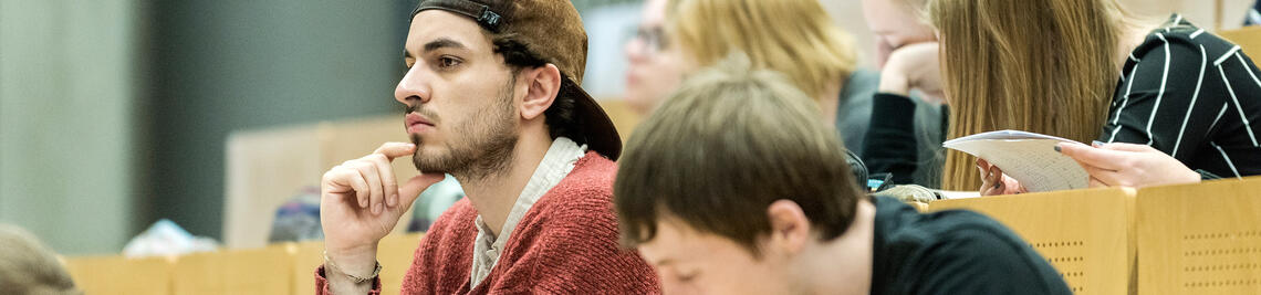 Student mit Cap im Hörsaal