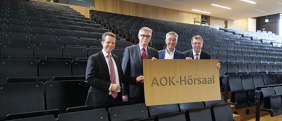 Der Hörsaal 0.004 im Z6-Gebäude wird zum AOK-Hörsaal. Von rechts: Unipräsident Alfred Forchel, AOK-Direktor Horst Keller, Unikanzler Uwe Klug und Thorsten Stegh von der Uni Würzburg GmbH.