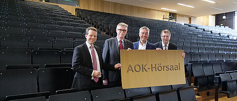 Der Hörsaal 0.004 im Z6-Gebäude wird zum AOK-Hörsaal. Von rechts: Unipräsident Alfred Forchel, AOK-Direktor Horst Keller, Unikanzler Uwe Klug und Thorsten Stegh von der Uni Würzburg GmbH.