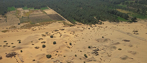 Ägyptische Tempelanlagen unterhalb des Bergs Jebel Barkal im Nordsudan; im Hintergrund der Nil. Das Foto visualisiert den Kontrast zwischen Kultur- und Naturlandschaft aus altertumswissenschaftlicher Perspektive.