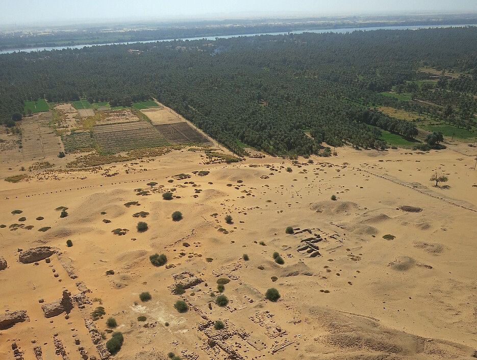 Ägyptische Tempelanlagen unterhalb des Bergs Jebel Barkal im Nordsudan; im Hintergrund der Nil. Das Foto visualisiert den Kontrast zwischen Kultur- und Naturlandschaft aus altertumswissenschaftlicher Perspektive.