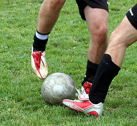 Im Sportrasen lauern - eher keine Zecken. Auch wenn dieser Rasen vermutlich nicht ganz so gepflegt ist wie der in den österreichischen EM-Stadien. Foto: bhp / Pixelio.de Zwei Fußballer kämpfen um den Ball.